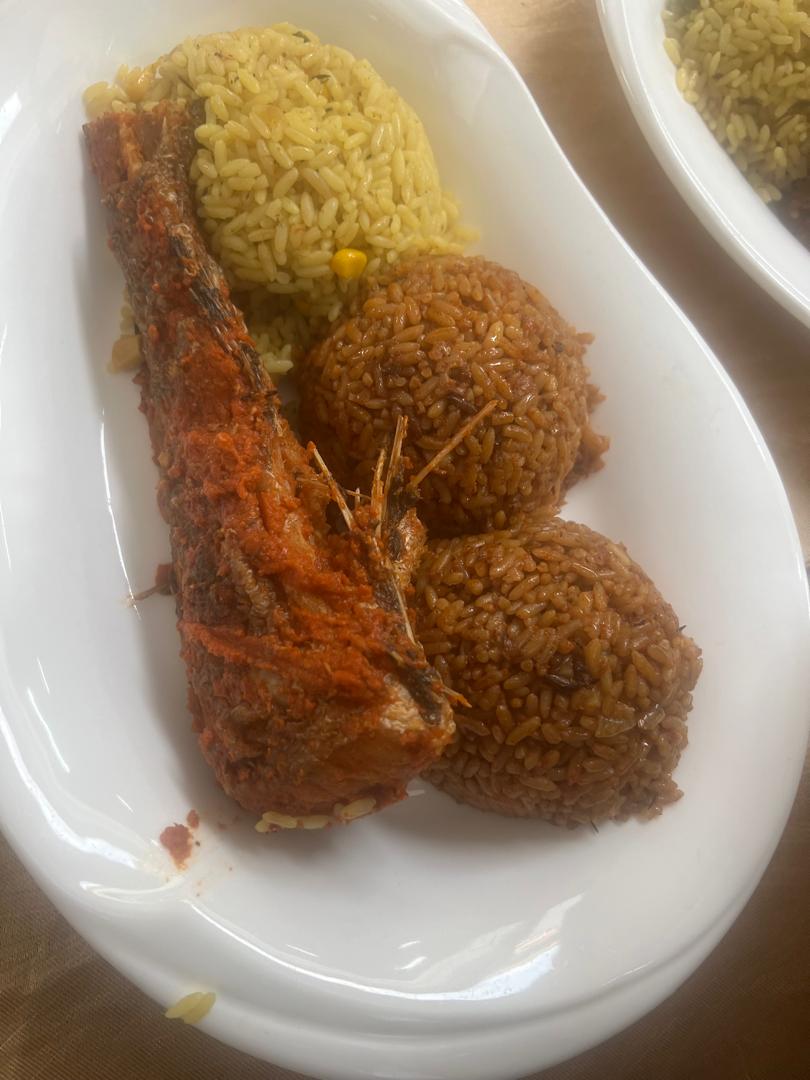 Jollof and fried rice served with fried fish
