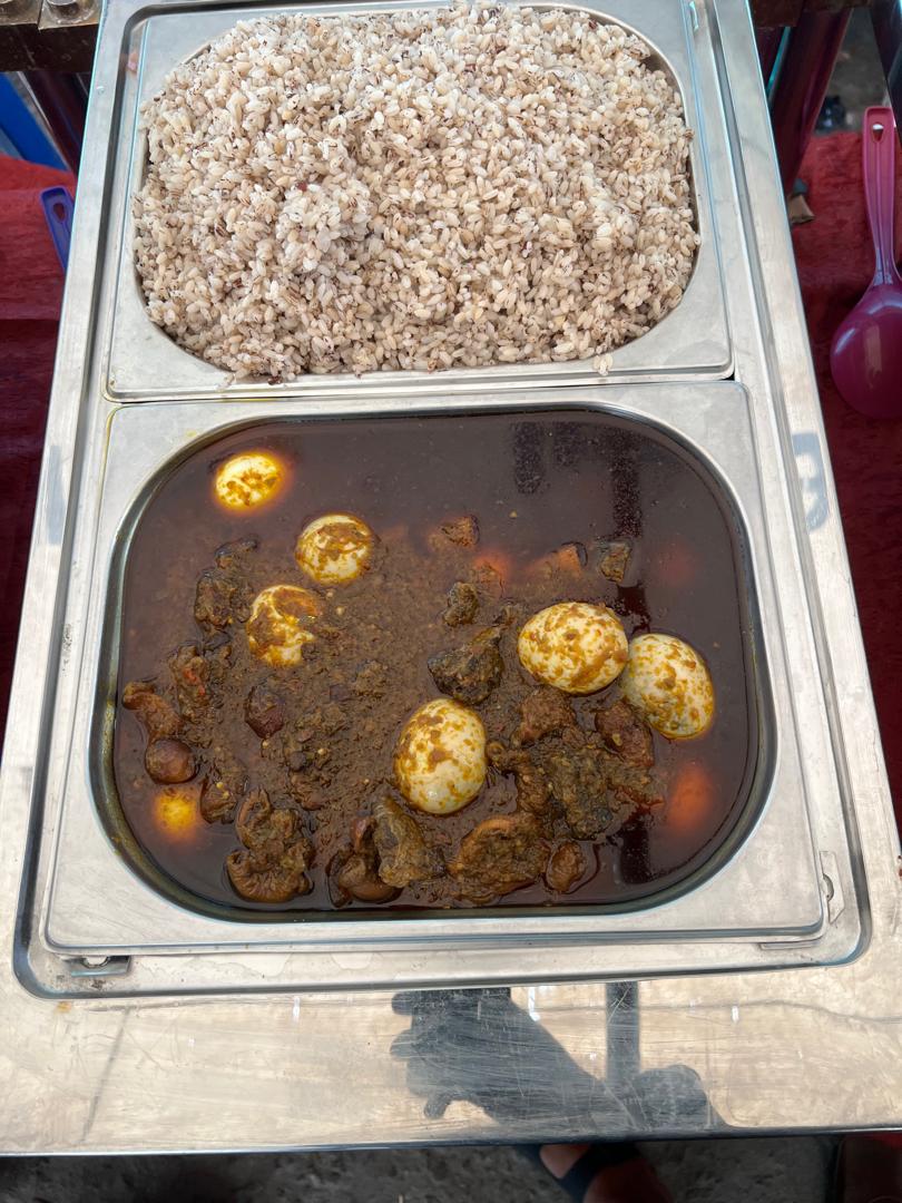 Local rice with rich stew and boiled eggs